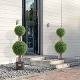 Three potted topiary plants in front of a modern building entrance.
