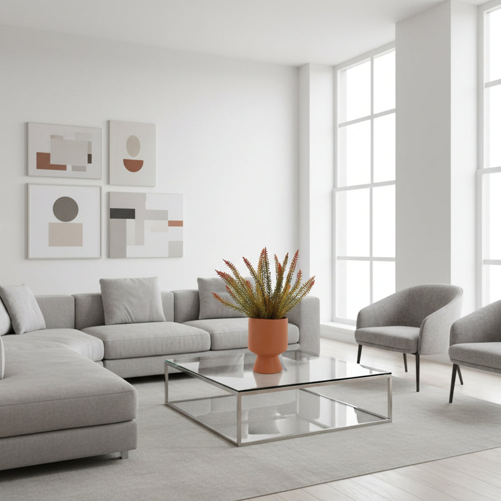 Artificial plant in a terracotta pot on a white background